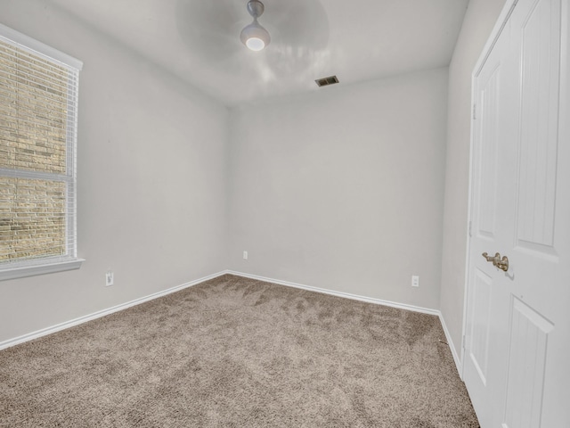 unfurnished room with a ceiling fan, baseboards, visible vents, and carpet flooring