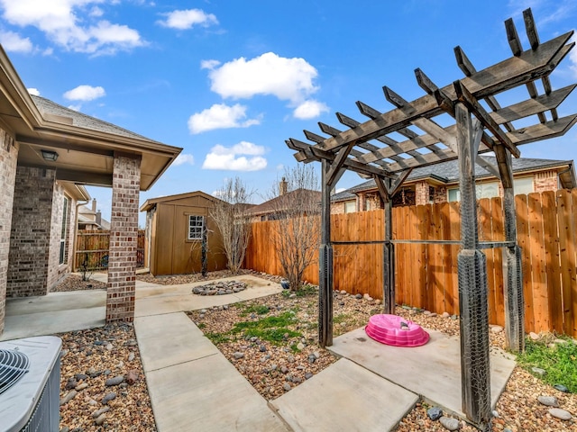 view of yard with an outbuilding, central AC, a fenced backyard, and a pergola