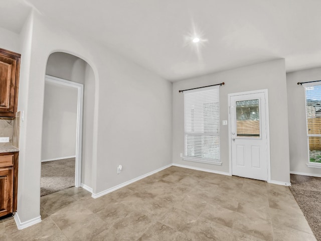 interior space with arched walkways and baseboards