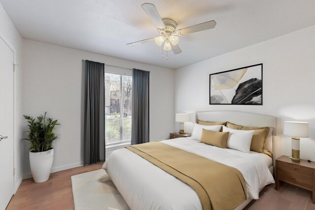 bedroom featuring ceiling fan, wood finished floors, and baseboards