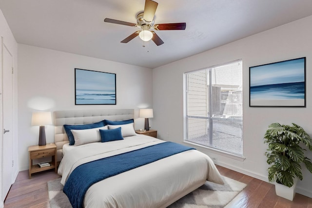 bedroom with wood finished floors, a ceiling fan, and baseboards