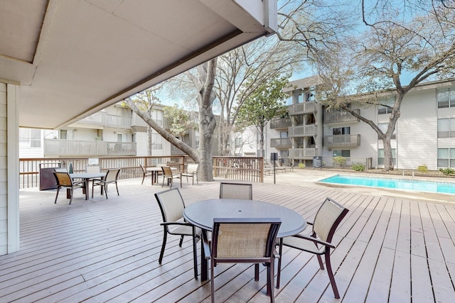 wooden deck featuring a fenced in pool and outdoor dining space