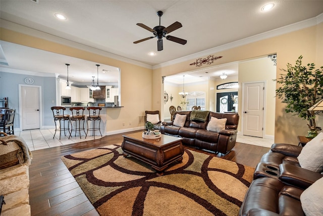 living area featuring ornamental molding, recessed lighting, baseboards, and hardwood / wood-style flooring