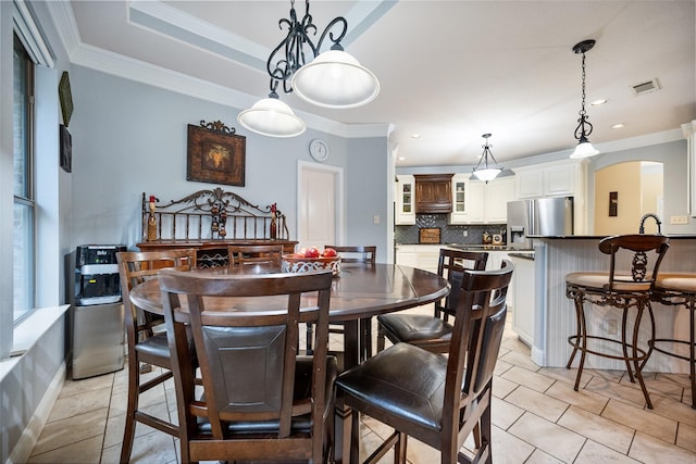 dining room with arched walkways, ornamental molding, and visible vents