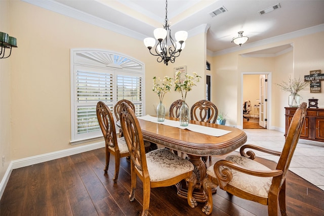 dining area with wood-type flooring, visible vents, and baseboards