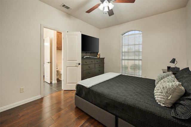 bedroom featuring lofted ceiling, connected bathroom, a ceiling fan, visible vents, and dark wood finished floors