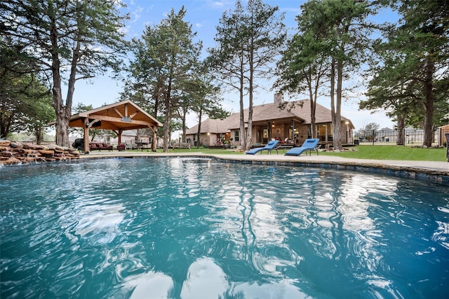 view of swimming pool featuring fence, a gazebo, and a lawn