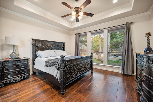 bedroom with a ceiling fan, a raised ceiling, crown molding, and hardwood / wood-style flooring