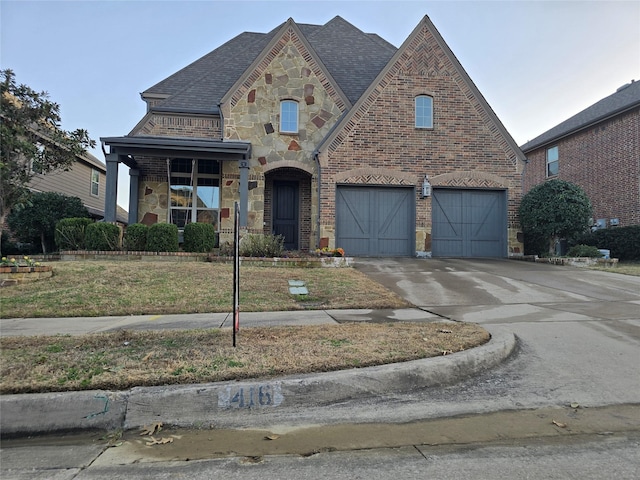 view of front of property with brick siding, a shingled roof, a garage, stone siding, and driveway