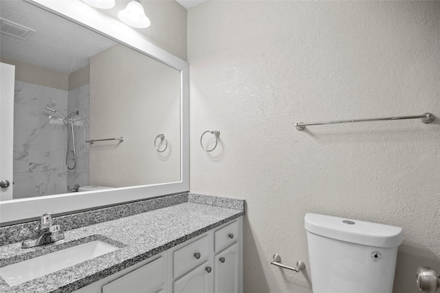 full bath with visible vents, a textured wall, toilet, vanity, and walk in shower