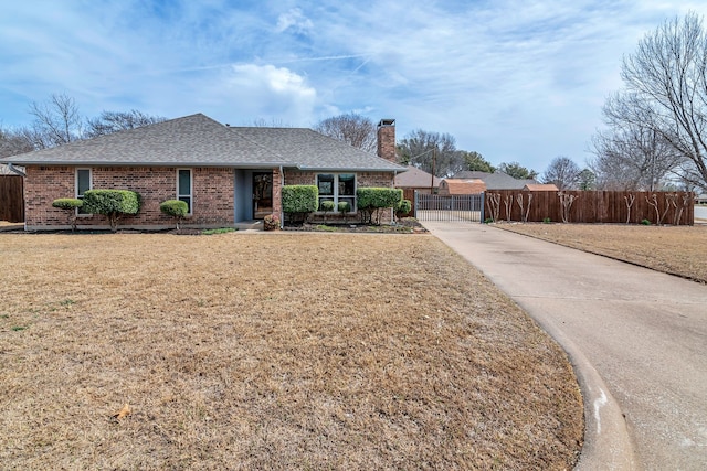 single story home featuring fence, a front lawn, and brick siding