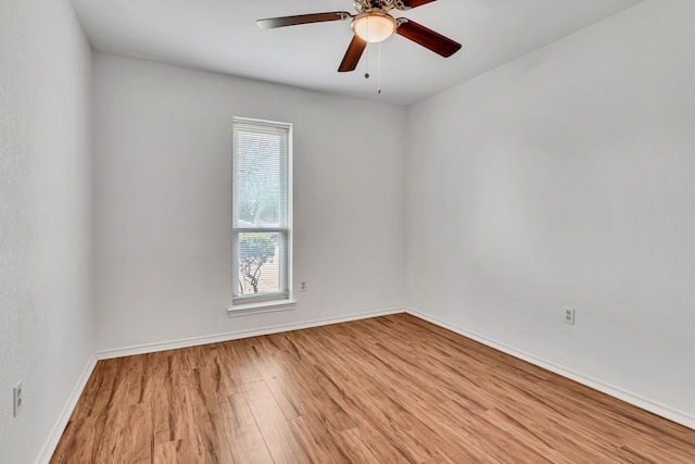 unfurnished room with light wood-type flooring, a ceiling fan, and baseboards