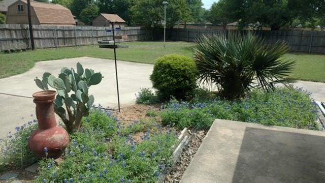 exterior space with a patio area, a fenced backyard, and a yard