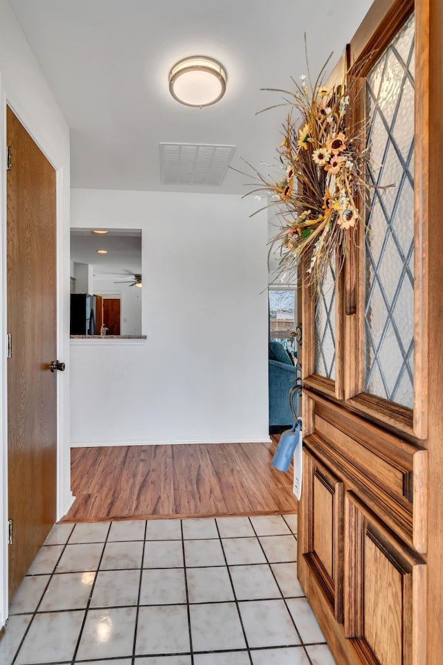 hall featuring visible vents and light tile patterned flooring