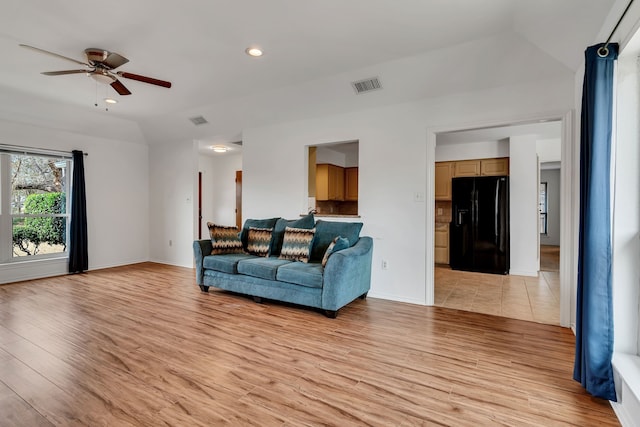 living area with lofted ceiling, ceiling fan, recessed lighting, visible vents, and light wood finished floors