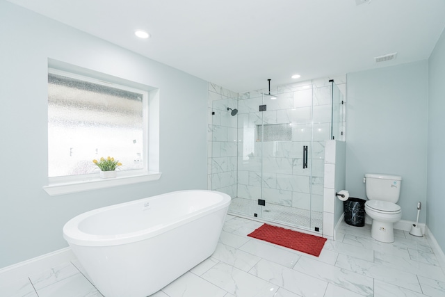 full bath with marble finish floor, visible vents, a shower stall, a freestanding tub, and baseboards