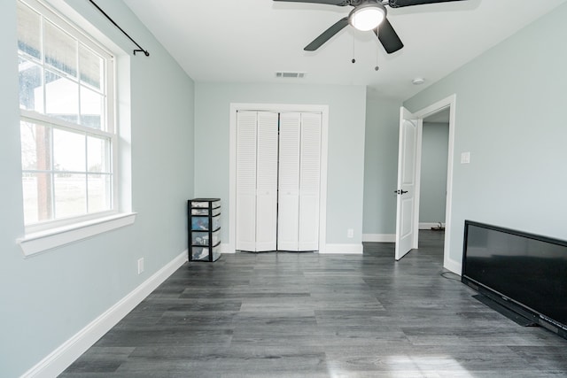 unfurnished bedroom with baseboards, visible vents, a closet, and wood finished floors