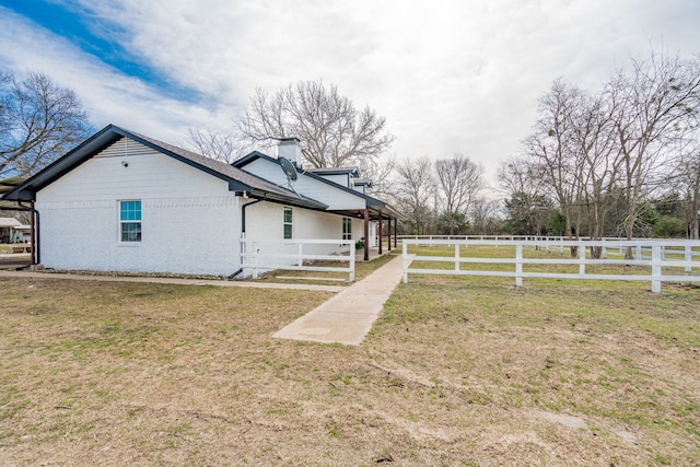 view of property exterior featuring a yard, a chimney, and fence