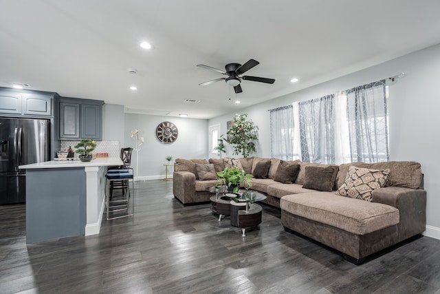 living area featuring baseboards, dark wood-type flooring, a ceiling fan, and recessed lighting