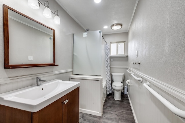 bathroom with toilet, a wainscoted wall, ornamental molding, and wood finished floors