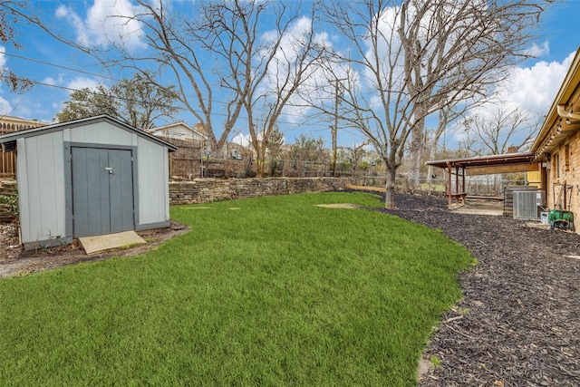 view of yard with a storage unit, an outdoor structure, and a fenced backyard