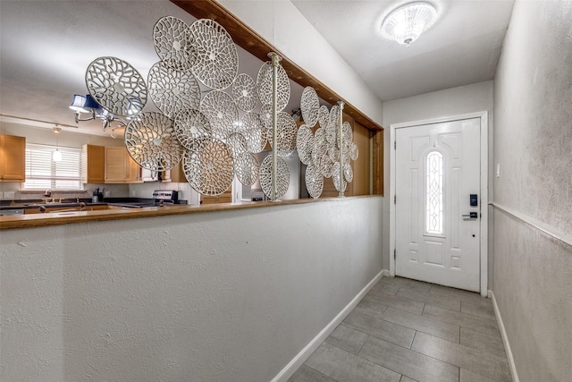 entrance foyer featuring light tile patterned floors and baseboards