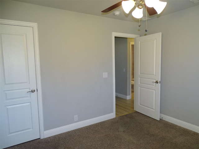 interior space with carpet flooring, a ceiling fan, and baseboards