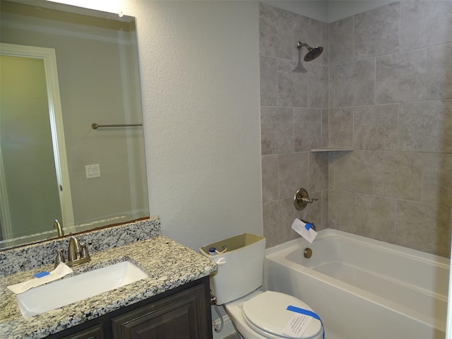 bathroom with toilet, a textured wall, vanity, and shower / bathtub combination