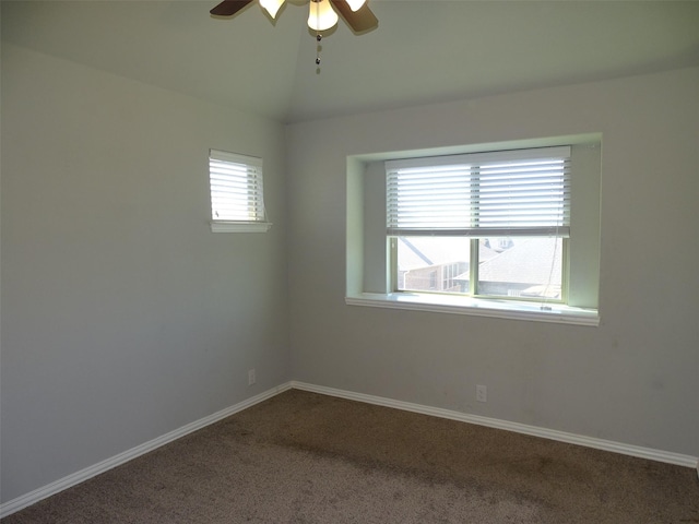 empty room featuring vaulted ceiling, ceiling fan, carpet flooring, and baseboards