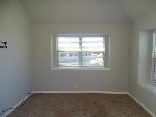 carpeted spare room with lofted ceiling and baseboards