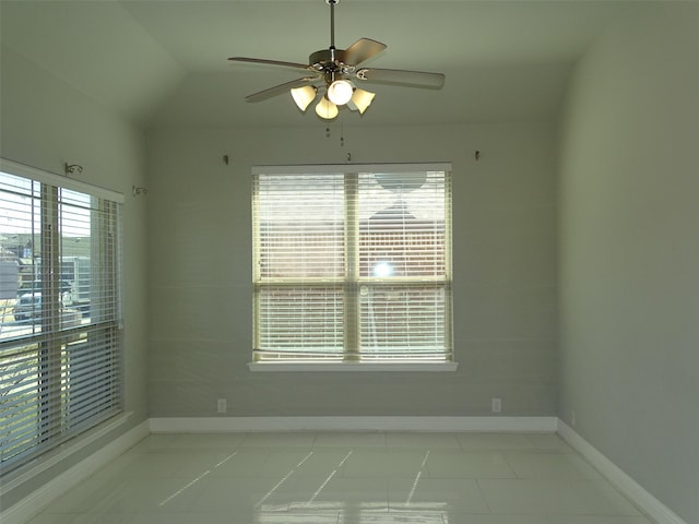 spare room with lofted ceiling, baseboards, and a ceiling fan