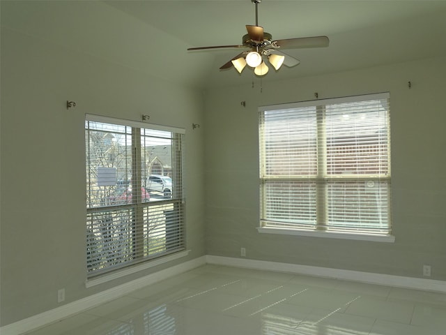 spare room with ceiling fan and baseboards