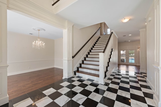 entryway with french doors, decorative columns, stairway, an inviting chandelier, and wood finished floors