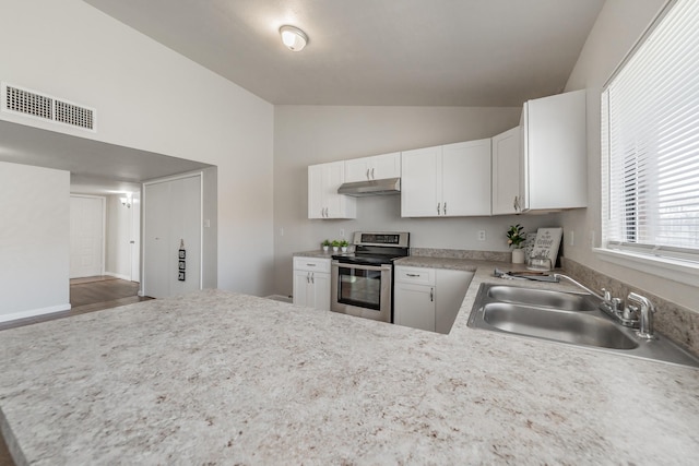 kitchen featuring visible vents, stainless steel range with electric stovetop, a sink, under cabinet range hood, and lofted ceiling