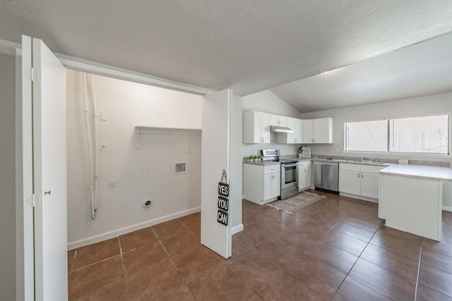 kitchen with under cabinet range hood, light countertops, appliances with stainless steel finishes, white cabinetry, and dark tile patterned flooring