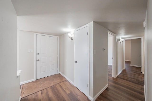 hallway with baseboards and wood finished floors