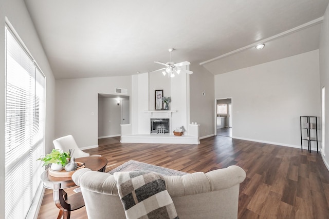 living room featuring baseboards, wood finished floors, visible vents, and a fireplace with raised hearth