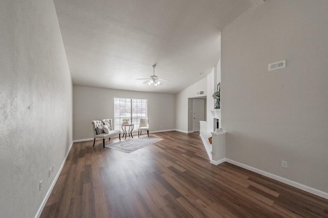 unfurnished room with a ceiling fan, baseboards, visible vents, a fireplace, and dark wood-type flooring