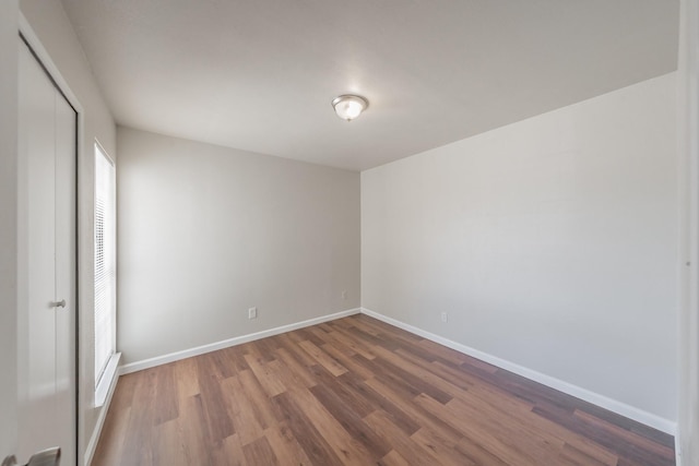 empty room featuring baseboards and wood finished floors