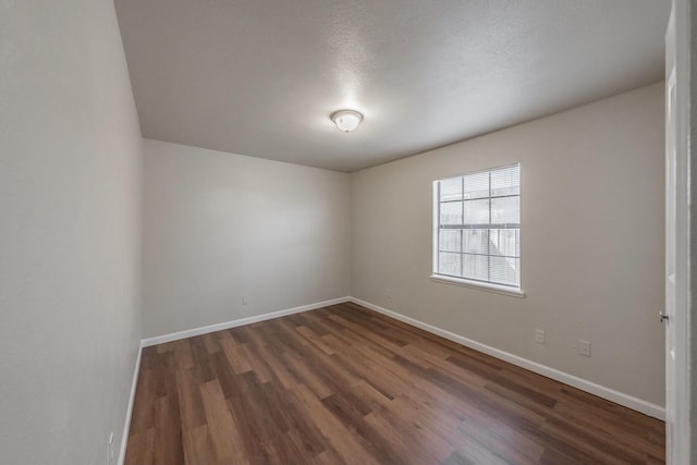 unfurnished room featuring baseboards and wood finished floors