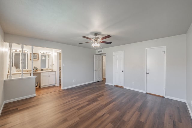 unfurnished bedroom featuring visible vents, baseboards, ensuite bath, and dark wood-style floors