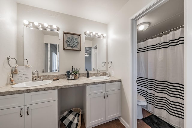 bathroom featuring double vanity, tile patterned floors, toilet, and a sink