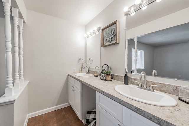 bathroom featuring tile patterned floors, double vanity, baseboards, and a sink