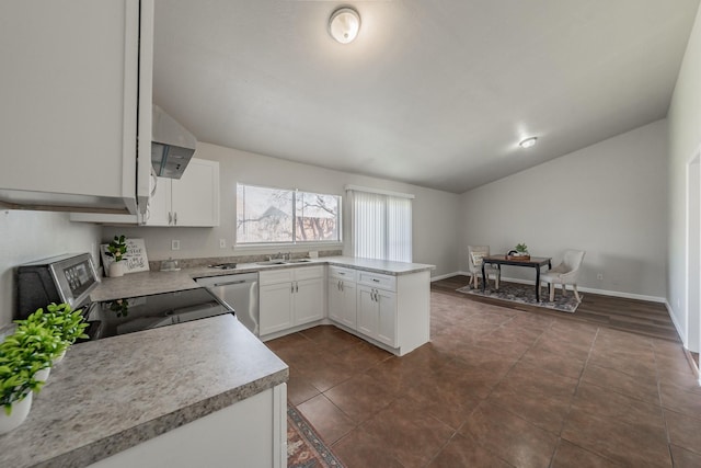 kitchen with stainless steel appliances, lofted ceiling, white cabinets, and wall chimney range hood