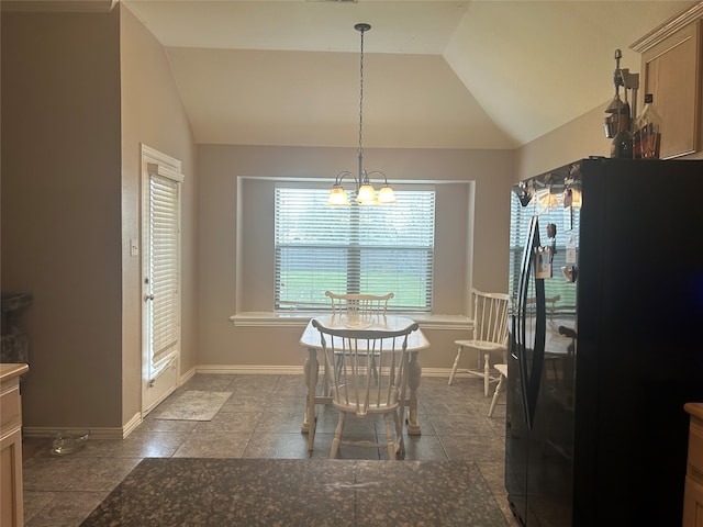 dining area with baseboards, lofted ceiling, and a chandelier