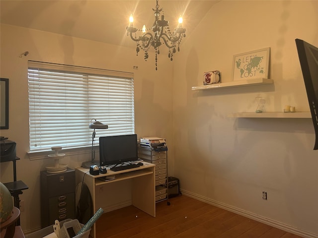 office space with baseboards, an inviting chandelier, vaulted ceiling, and hardwood / wood-style flooring