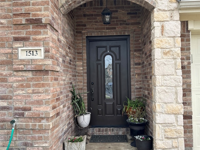 doorway to property with brick siding