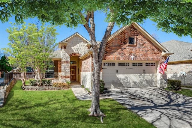 view of front of property featuring brick siding, a front lawn, fence, a garage, and stone siding