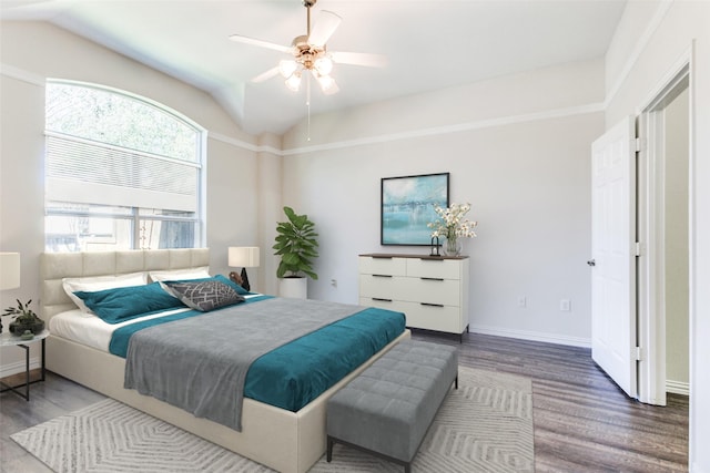 bedroom with vaulted ceiling, wood finished floors, baseboards, and ceiling fan