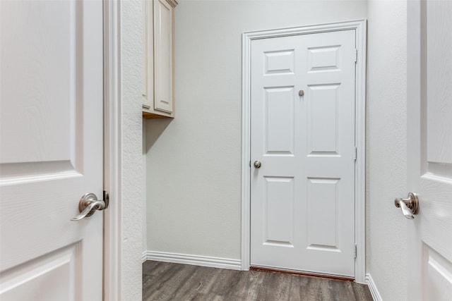 laundry room with baseboards and dark wood-style flooring